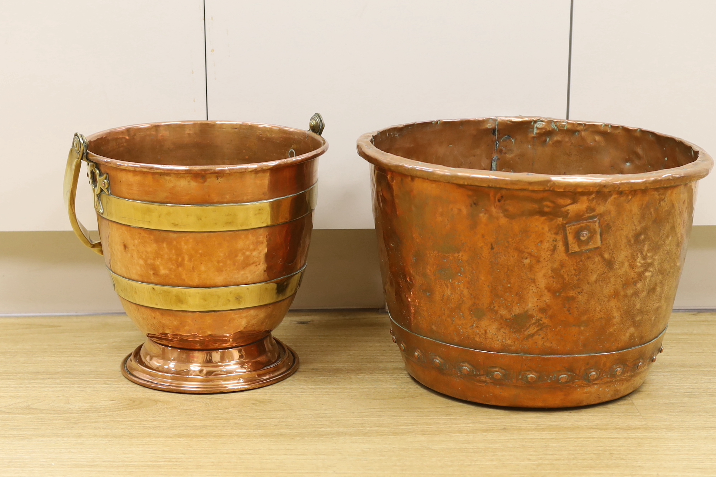 An Arts and Crafts copper and brass bucket, together with a copper embossed pot, both 30cm high